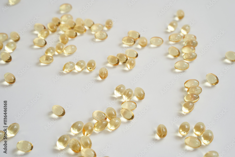 Clear capsules scattered on white background highlighting health and wellness supplements Clear capsules scattered on white background highlighting health and wellness supplements