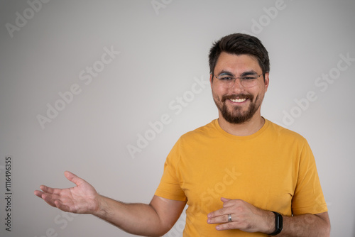 This idea just fascinated me. Attractive young unshaven individual with happy expression, indicates with index finger at blank copy space, advertises you place to vist, isolated over white ...  photo