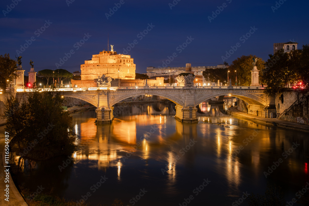 Fototapeta premium Night scenery of Ponte Vittorio Emanuele II across the River Tiber with Castel Sant'Angelo, a famous landmark in Rome, Italy, in the background.