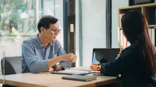 Focused Conversation: A professional business meeting in progress, with two individuals engaged in a serious discussion. The image evokes an atmosphere of concentration and collaboration. 