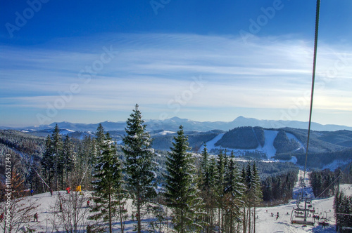 snowy landscape at the ski resort, snowy slopes and fir trees, ski lift route