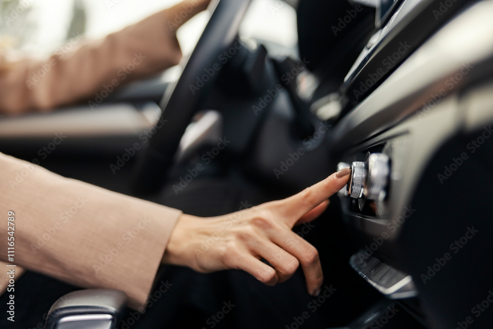 Close up of female driver's hand pushing button in her car. Close up of female driver's hand pushing button in her car.