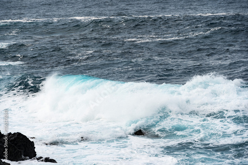 North coast of Tenerife, Canary Islands, waves breaking against dark lava rocks. photo