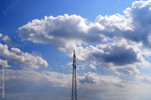 Electric power tower with lines against cloudy sky, transporting electrical energy