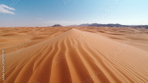 An expansive view of a desert with long, gentle sand dunes under a bright blue sky, capturing the tranquility and vastness of the natural landscape.