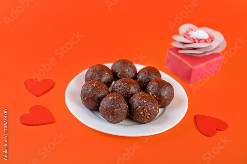 Nuts dates cocoa powder vegetarian balls in a white plate for Valintine's day holiday photo