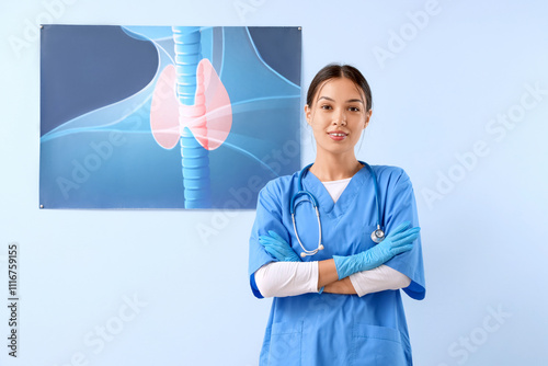 Female Asian endocrinologist against picture of thyroid gland on blue background photo