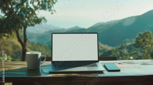 laptop computer With mobile phone on table in coffee shop with hills background