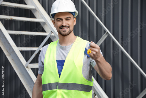 Male builder with earplugs ...