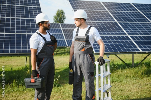 A team of two engineers are working to install solar panels at a solar power station. Engineer team discussing the work to install solar cells photo