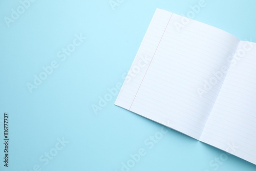 Open copybook on light blue background, top view. Space for text