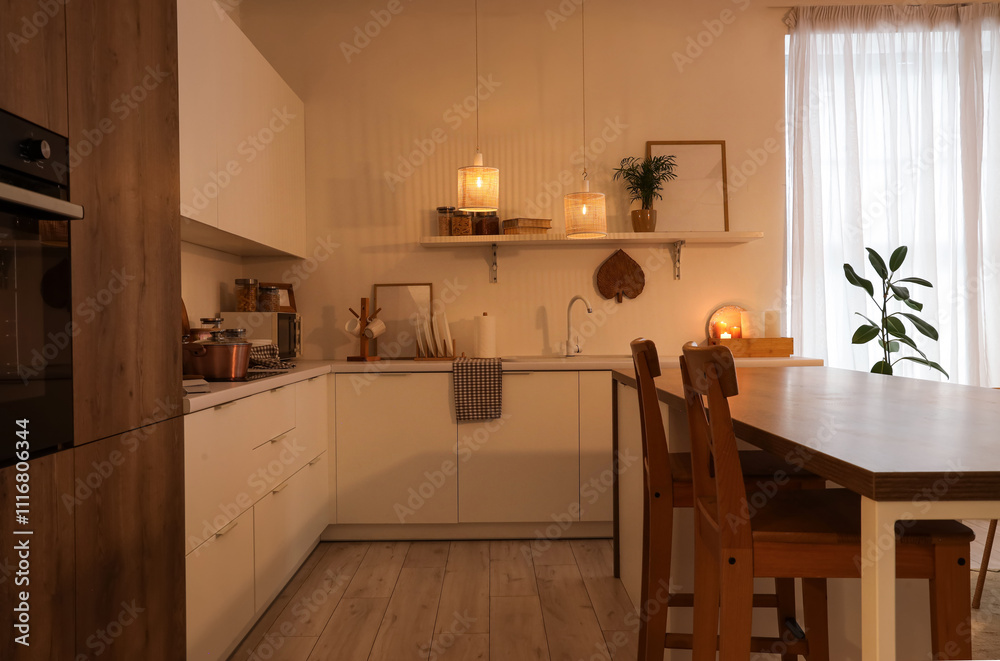 Interior of kitchen with shelf, counters and glowing lamps in evening Interior of kitchen with shelf, counters and glowing lamps in evening