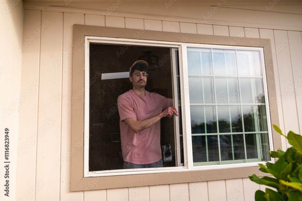Man standing in home window Man standing in home window