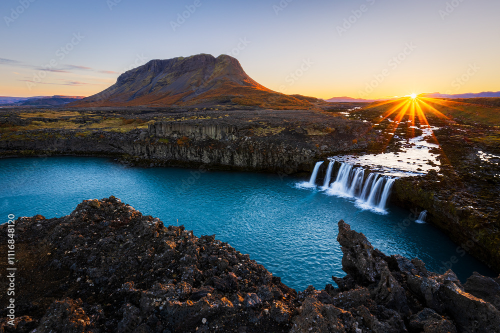 Fototapeta premium Mount Burfell and Þjófafoss (Thjofafoss) waterfall at sunrise located on the river Thjorsa in the south of Iceland.
