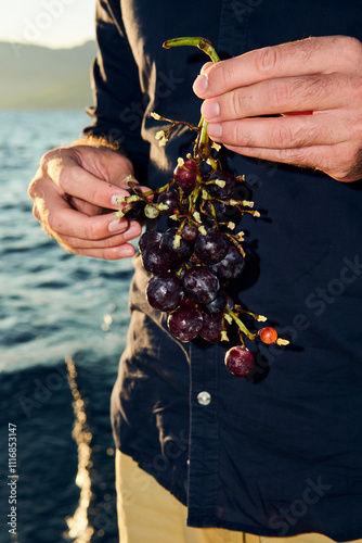 Close up of a person holding cluster of grapes photo