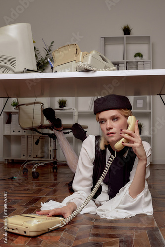 A Stylish Woman with phone Under a Desk in a Modern Office 