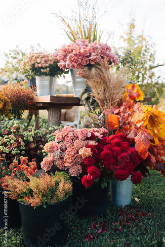 Outdoor floral arrangement with colorful buckets and leaves photo