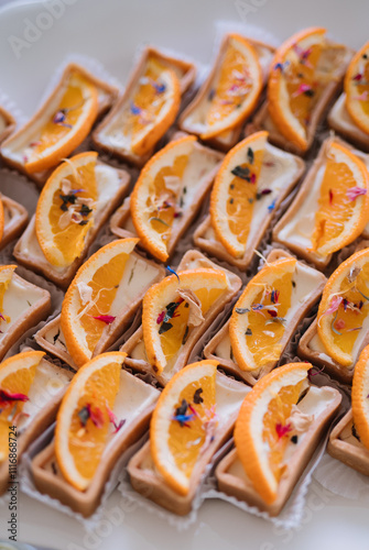 Close-up of orange-flavored mini tartlets on a plate. photo