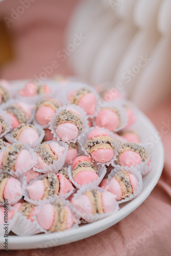 Plate of pink and brown pastry puffs on a festive table photo