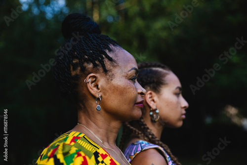 Side profile of African mother and daughter outdoors in traditio photo