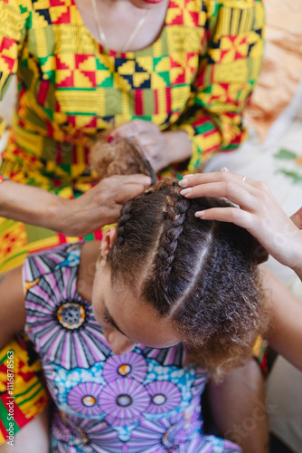 Close-up of mother braiding daughter's hair photo