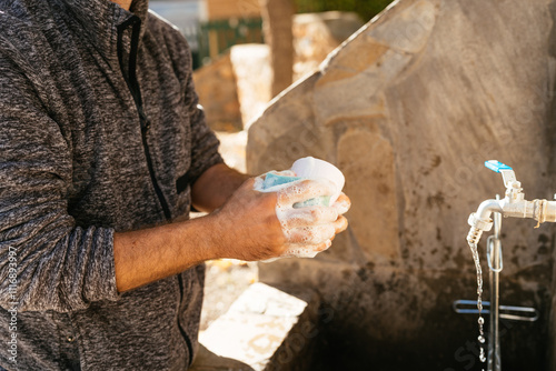 close up man washing dishes outdoors photo