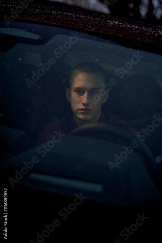 Young man ponders while gazing out car window