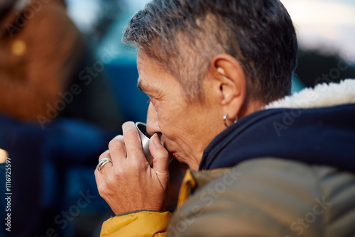 Woman sips a cup of tea at the campsite photo