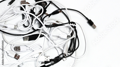 top down view close up of many tangled usb cords cables on white cluttered technology communication background photo