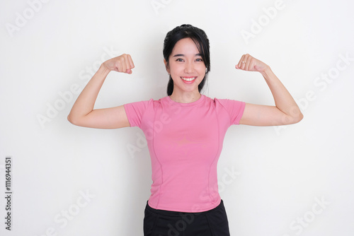 A woman smiling happy while showing her biceps muscle photo