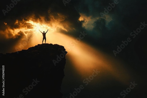 Solitary Figure Embracing Victory on Cliff Under Dramatic Sky with Light and Dark Contrast photo