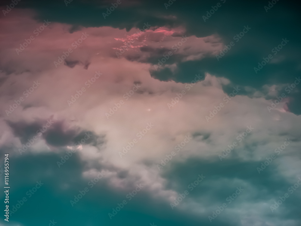 Obraz premium A dramatic, moody sky with dark clouds and a soft pink hue. Perfect for backgrounds or to evoke a sense of mystery and emotion