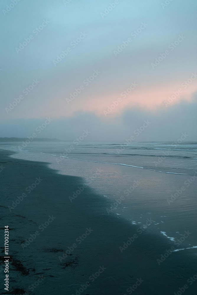 Fototapeta premium A serene beach scene at dusk, shrouded in mist and soft colors.