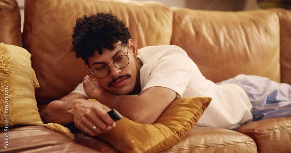 Man, relax or watching TV on sofa with choice, decision or browsing media with remote in home. Person, bored or change volume in living room with comfort, entertainment or check subscription platform