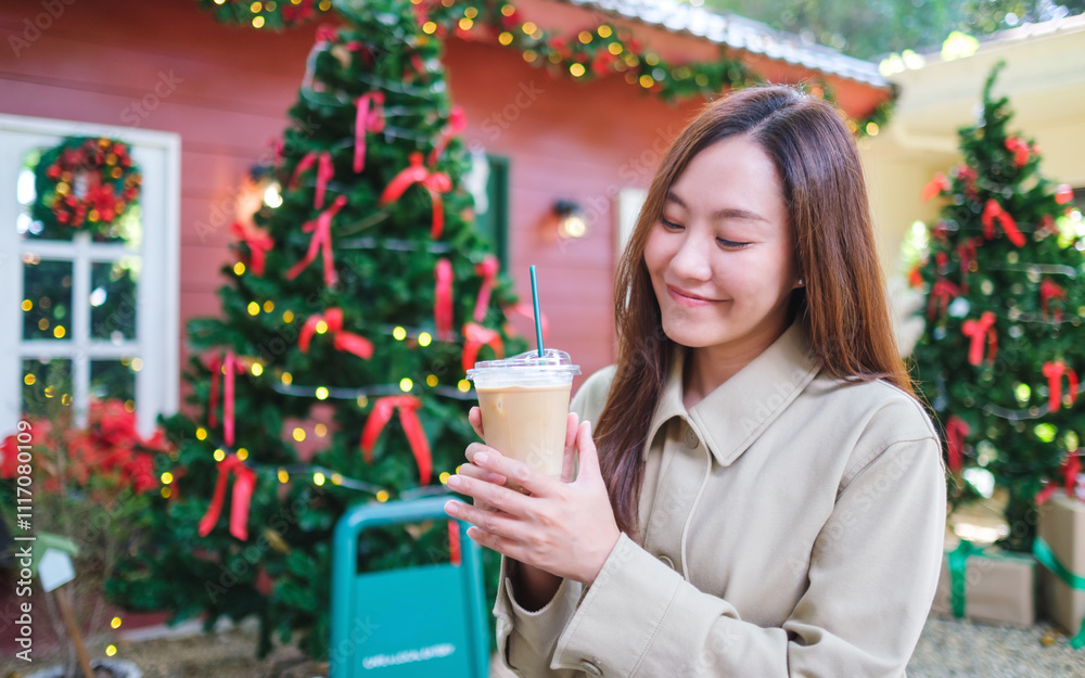 Portrait image of a woman holding and drinking iced coffee in Christmas party Portrait image of a woman holding and drinking iced coffee in Christmas party