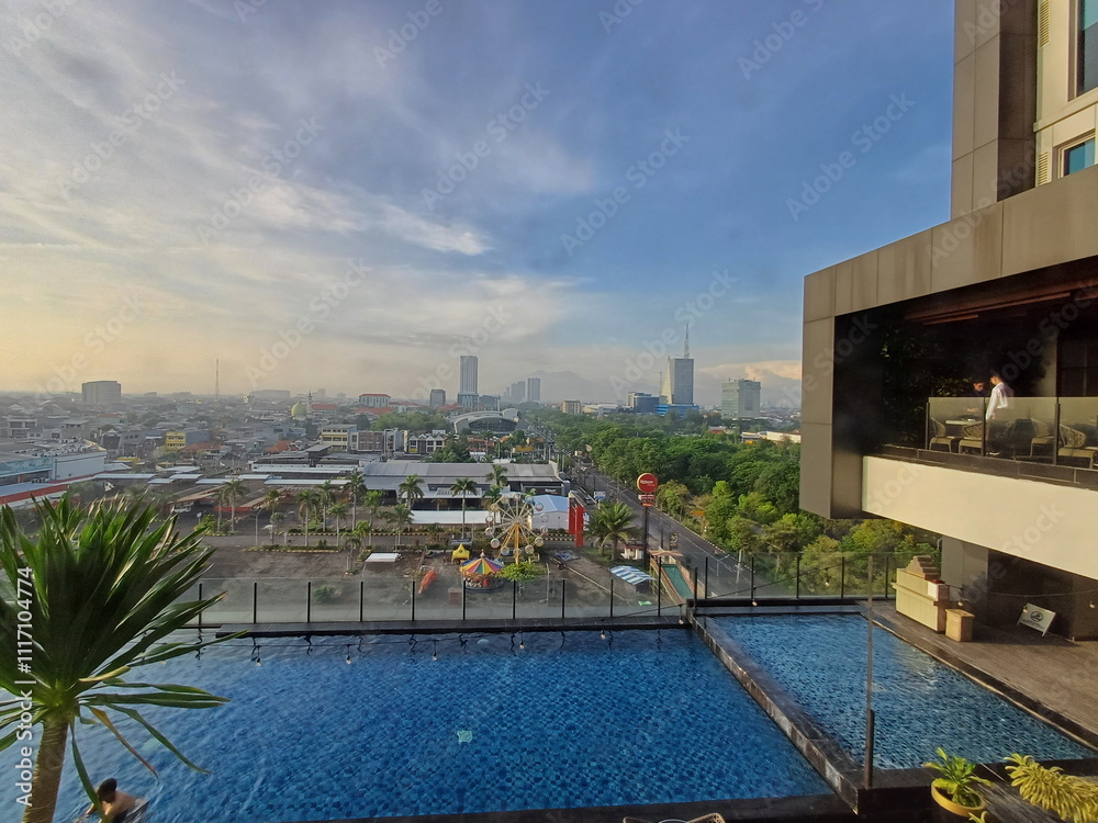 Fototapeta premium Cityscape View from Rooftop Pool at Sunrise