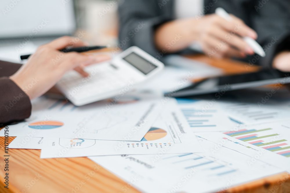 Close-up of hands working with financial documents, calculator, and tablet, focusing on data analysis and business strategy. Close-up of hands working with financial documents, calculator, and tablet, focusing on data analysis and business strategy.