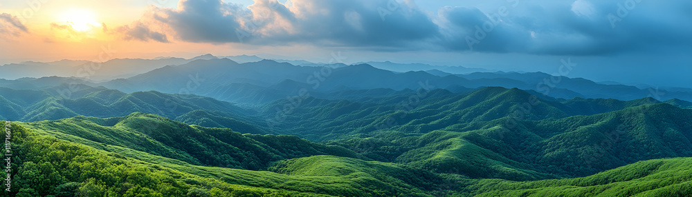 Obraz premium Sunset over rolling green hills and mountains.