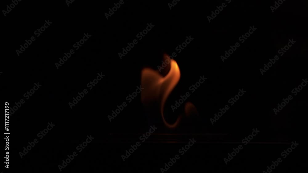 plan fixe en slow motion de flammes très graphiques qui apparaissent très lentement sur un fond noir