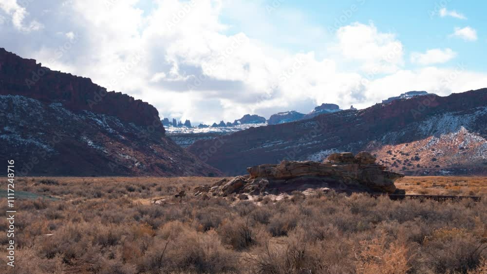 Wide shot of a large mountain range with dead shrubs, and snow covered peaks on a sunny day. Wide shot of a large mountain range with dead shrubs, and snow covered peaks on a sunny day.