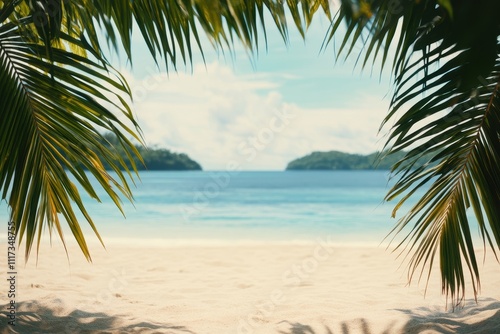 A serene beach view framed by palm leaves, showcasing tranquil waters and distant islands.