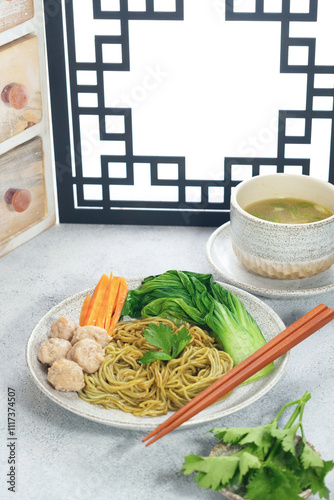 Healthy noodles made from vegetables served with beef meatballs complete with green mustard, celery, sliced ​​carrots and a bowl of meatball sauce - Photographed using Chinese style background photo