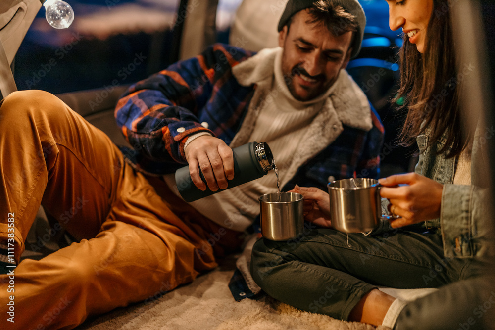 Man and woman sharing hot beverages in a car trunk setup Man and woman sharing hot beverages in a car trunk setup