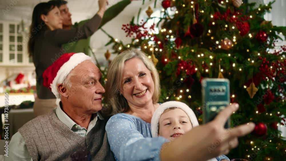 Happy family taking pictures by smartphone in Christmas eve, celebrate together. Grandparents, parents and little boy spending time joint in winter vacation, happy childhood moments, portrait shot