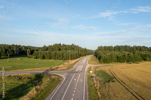 Aerial View of a Rural Road Intersection With Trees and Fields on a Sunny Day