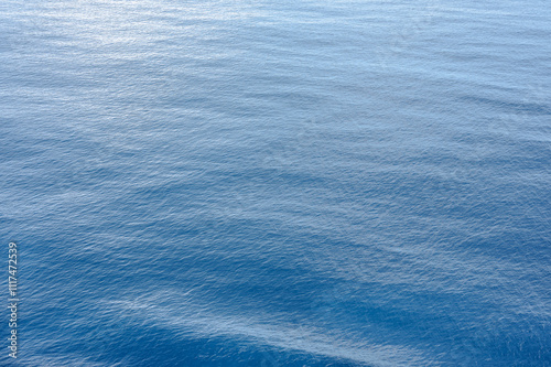 tranquil ocean water background with soft waves and subtle ripples. Blue sea surface reflects light. backgrounds, wallpapers, and nature-related projects. Captures essence of marine tranquility