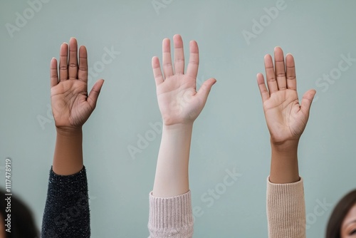 Three people are raising their hands in the air, possibly to show agreement or support. Concept of unity and positivity