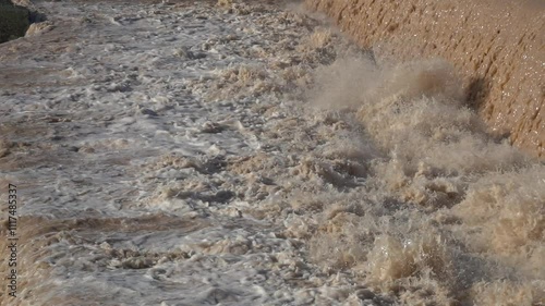  Strong flow of water and mud on a riverbed, in slow motion