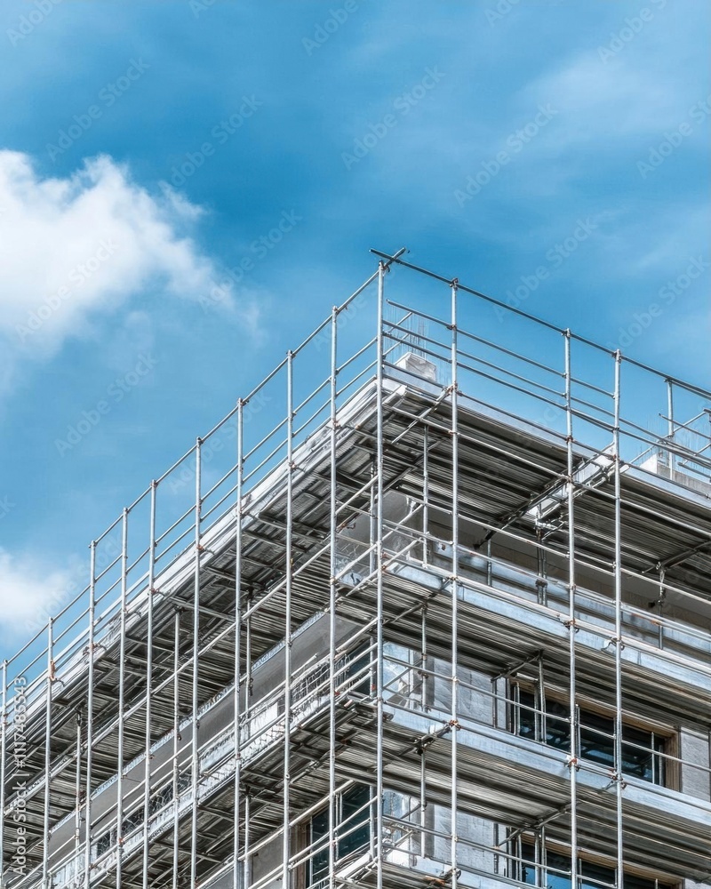 Scaffolding on a building against a blue sky with clouds. Scaffolding on a building against a blue sky with clouds.