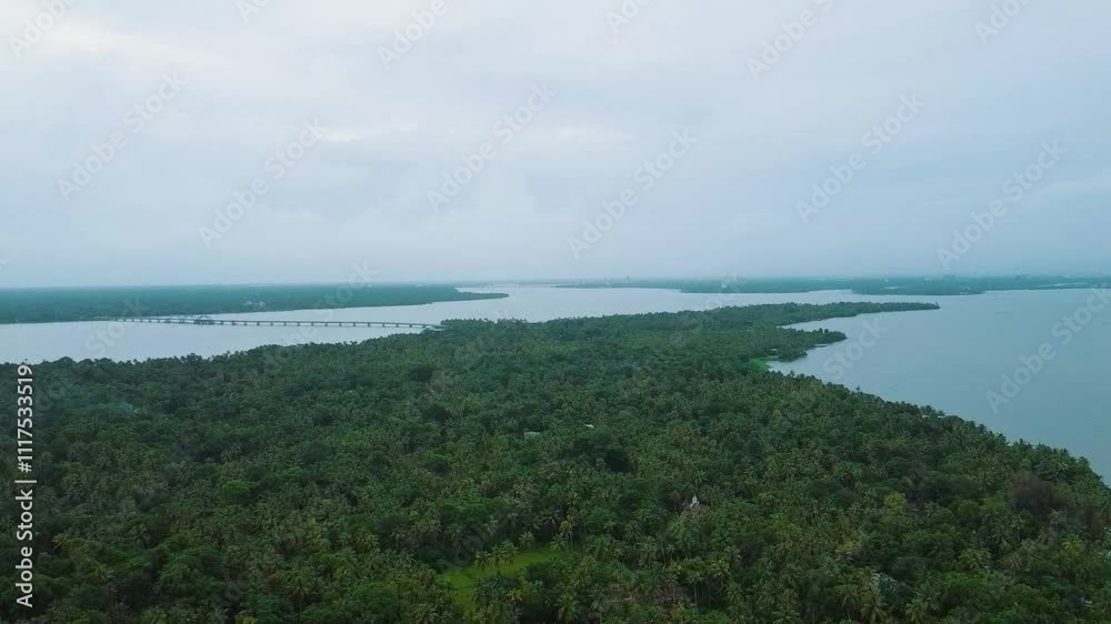Bridge connecting two islands, Morning areal view of a beautiful green island in Vembanadu lake in Kerala. Areal view of Coconut Plant rich area, Perumbalam, Alleppy.India,Asia Bridge connecting two islands, Morning areal view of a beautiful green island in Vembanadu lake in Kerala. Areal view of Coconut Plant rich area, Perumbalam, Alleppy.India,Asia